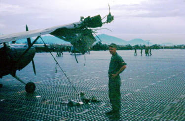 Unidentified crew chief at Marble Mountain airport, 1966, following a mortar attack